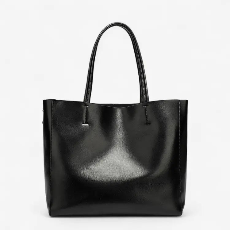 Sac cabas femme en cuir noir brillant avec anses longues, style porté épaule.
