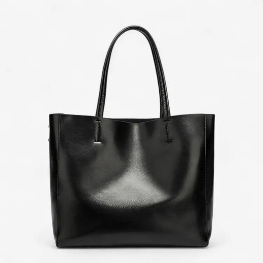 Sac cabas femme en cuir noir brillant avec anses longues, style porté épaule.