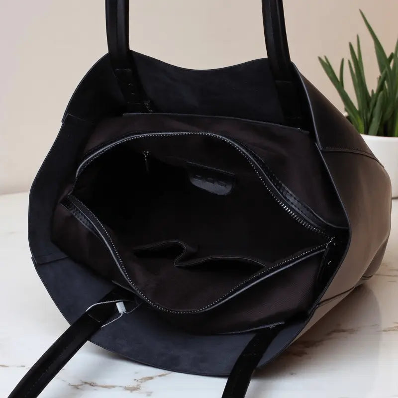 Intérieur du sac cabas femme en cuir noir avec poches et compartiment principal.