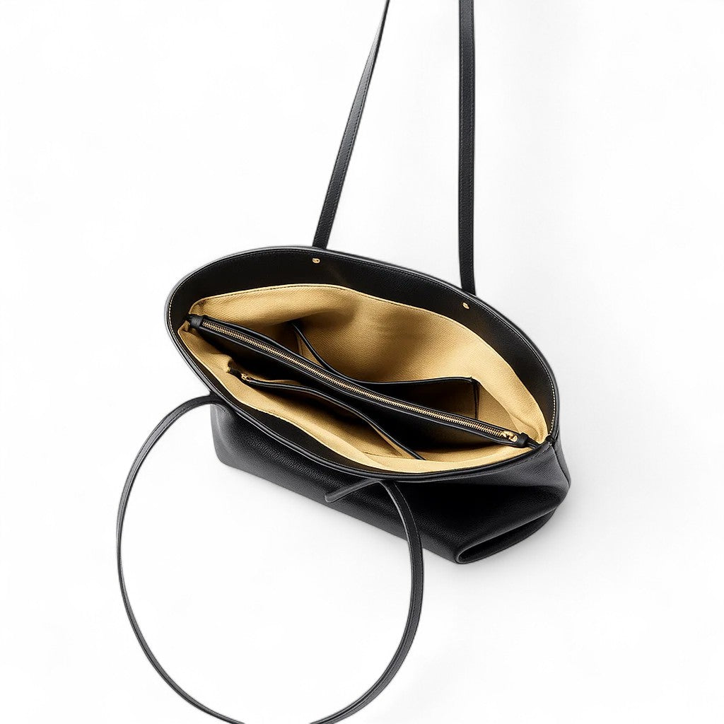 Vue du sac cabas noir ouvert, intérieur spacieux avec doublure beige et poches internes.