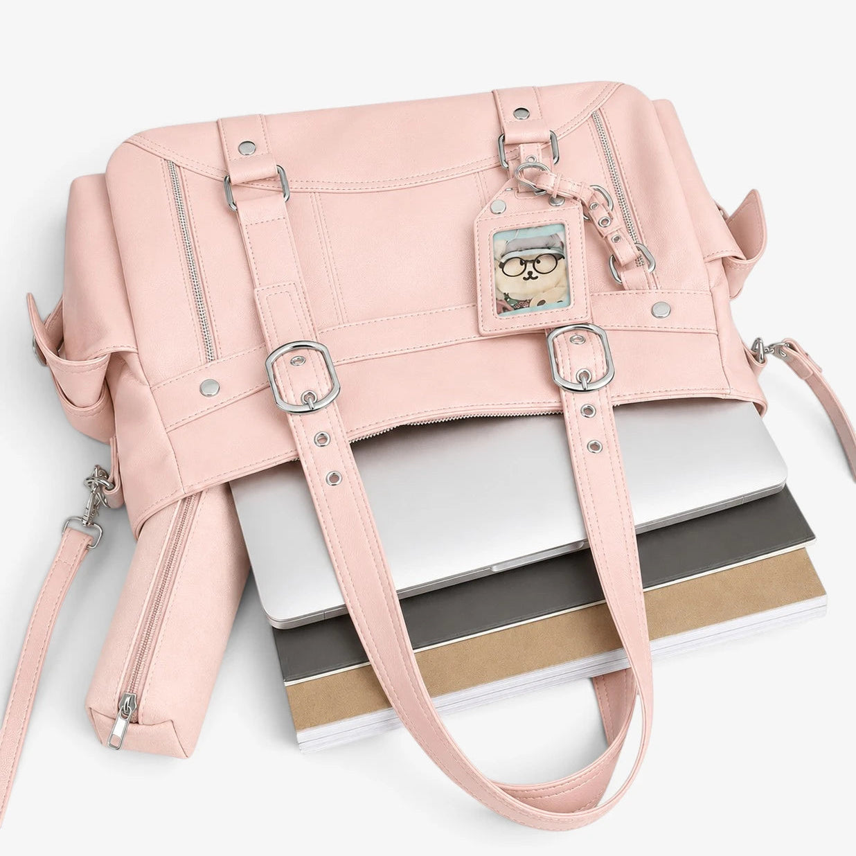 Sac cabas rose posé sur des livres avec bandoulière visible