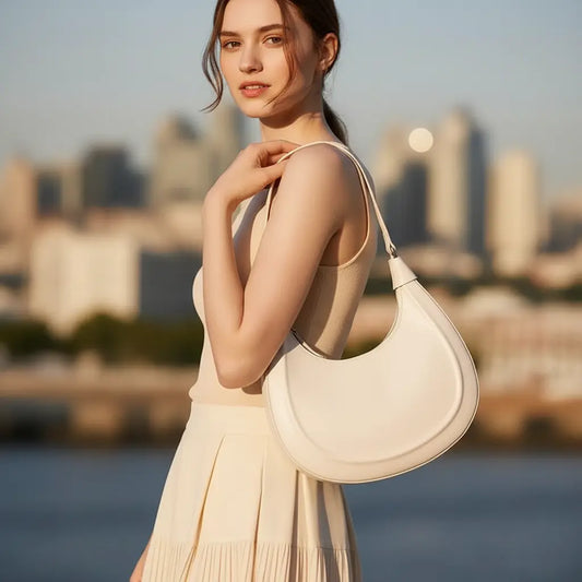 Femme portant un sac croissant blanc en cuir de vachette pleine fleur en ville.