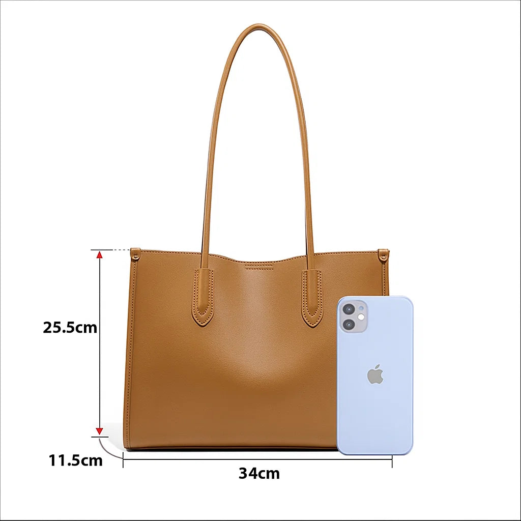 Sac en cuir camel avec dimensions indiquées 34 × 11,5 × 25,5 cm à côté d’un smartphone