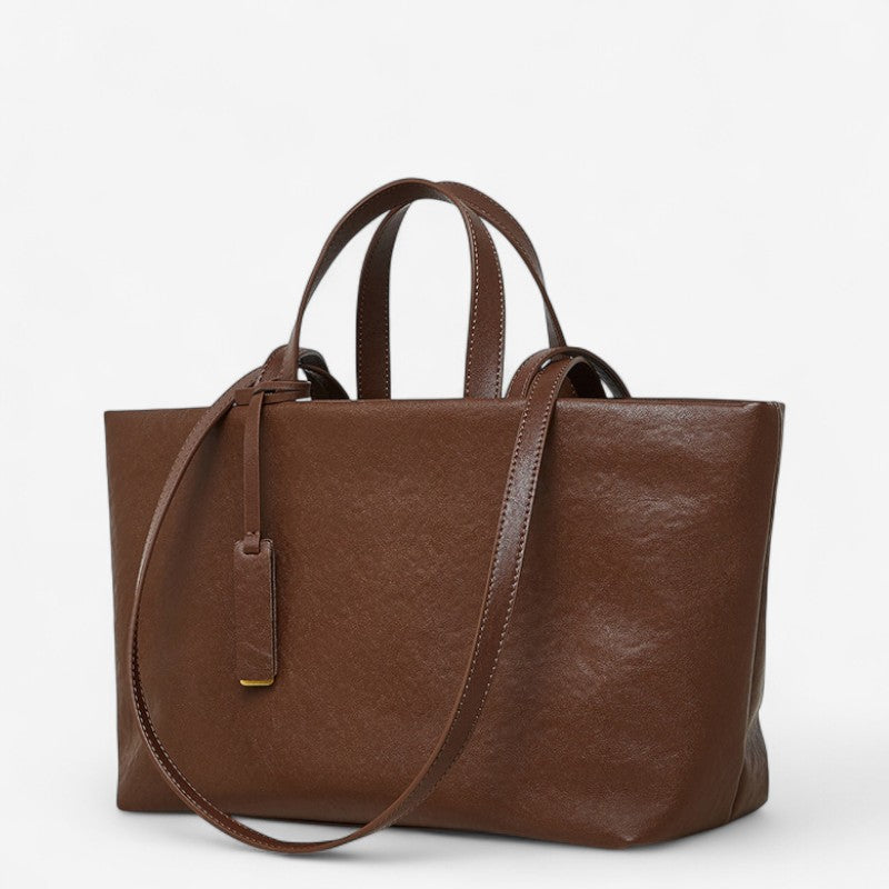 Vue avant du sac en cuir marron foncé pour femme avec étiquette suspendue