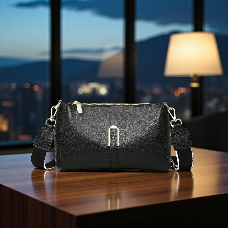 Sac en cuir de vachette noir posé sur une table en intérieur de nuit