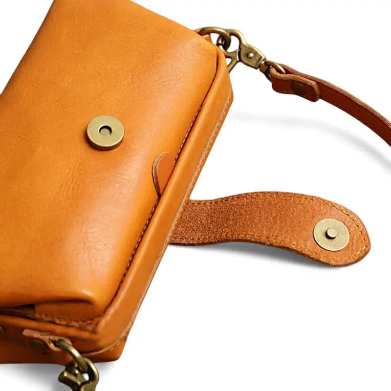 Détail du rabat et du bouton pression du sac en cuir véritable camel
