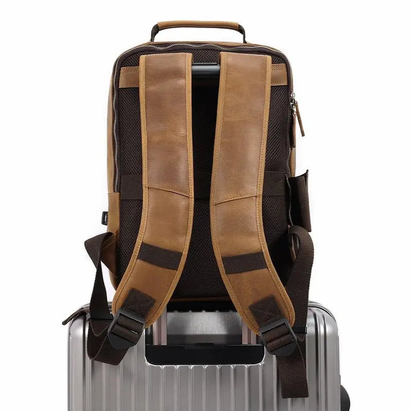 Sac à dos en cuir de vachette marron clair avec port USB fixé sur une valise