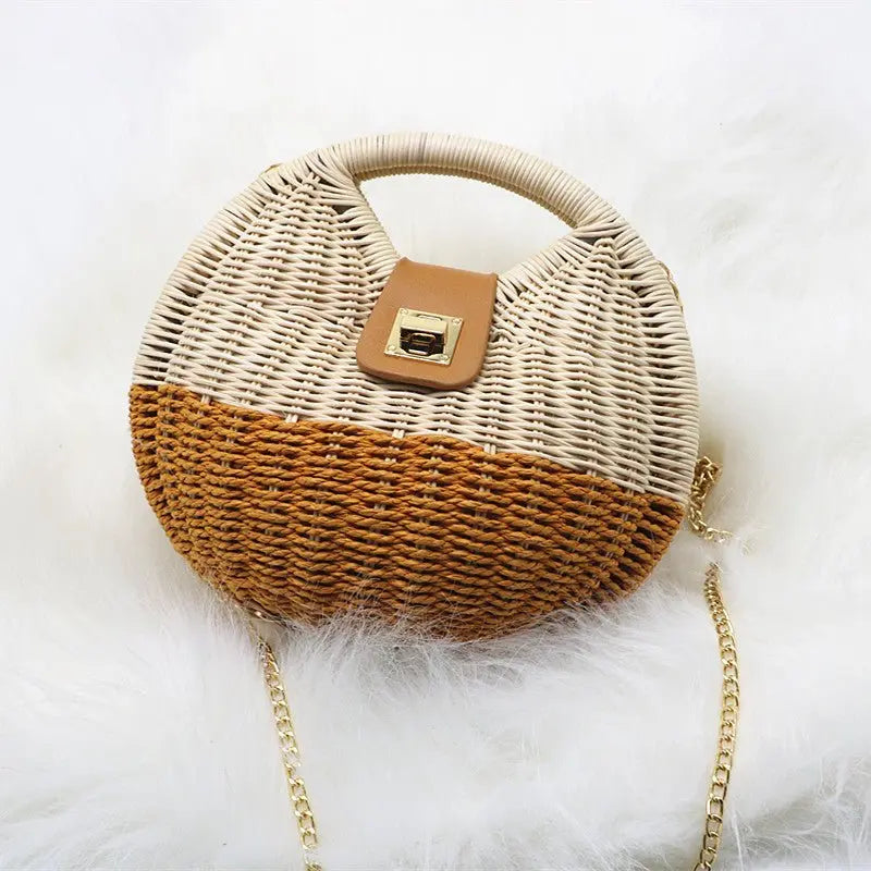 Sac en paille tressée rond bicolore avec rabat PU marron présenté sur fond en fourrure blanche