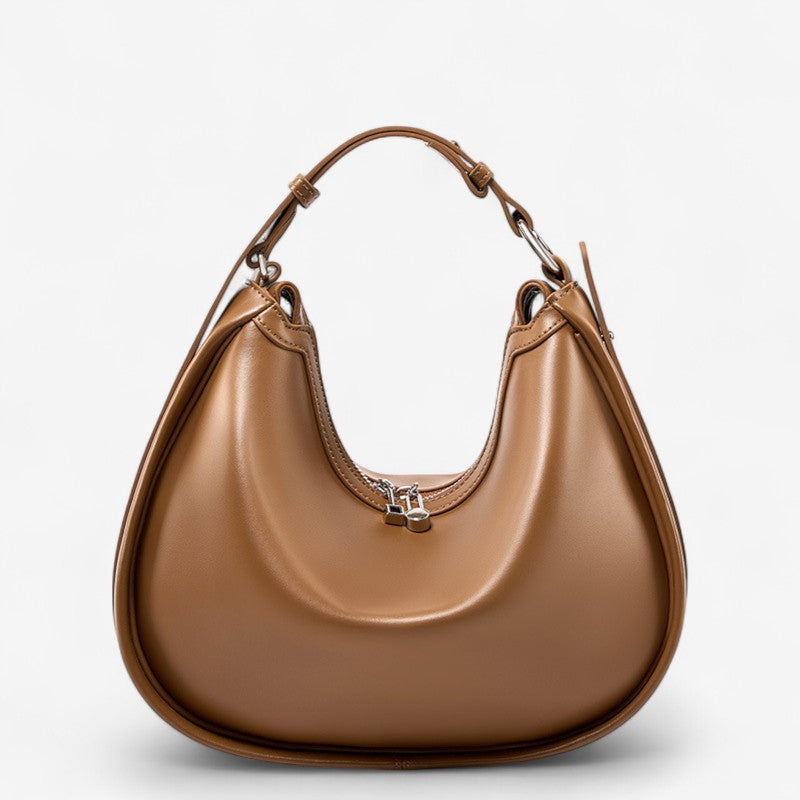 Vue de face du sac en cuir marron de forme croissant avec anse réglable et structure souple.