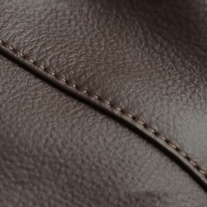 Détail de la couture sur cuir de vachette marron, texture souple et naturelle.