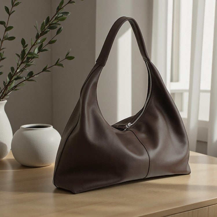 Sac porté épaule en cuir de vachette marron posé sur un support clair, vue produit.