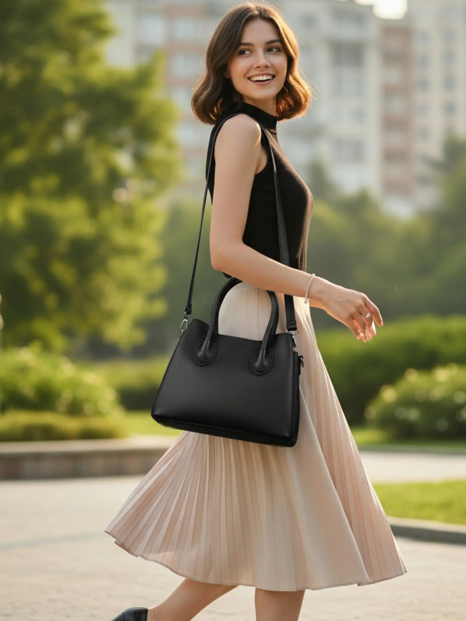 Sac femme en cuir de vachette noir porté à l’épaule en extérieur