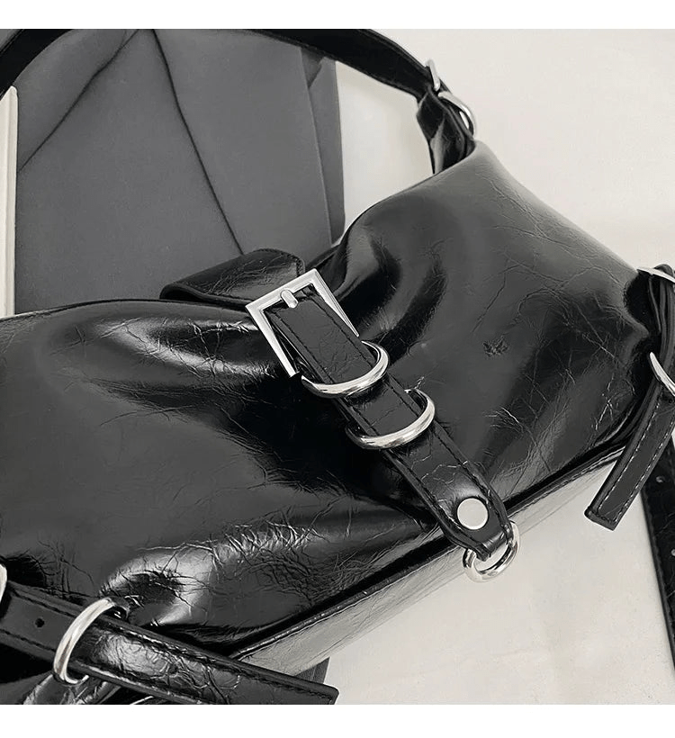Gros plan sur la boucle métallique du sac hobo en cuir synthétique vernis noir
