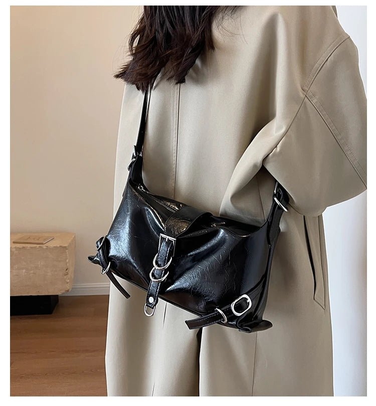 Sac hobo en cuir synthétique vernis noir porté à l’épaule avec style décontracté