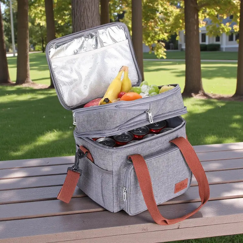 Sac isotherme gris ouvert montrant l’intérieur aluminium et des aliments sur une table