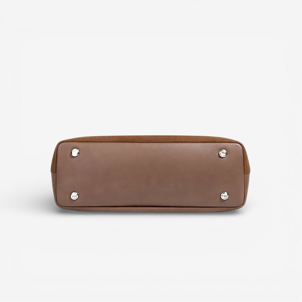 Vue du dessous du sac à main en cuir marron avec quatre renforts métalliques