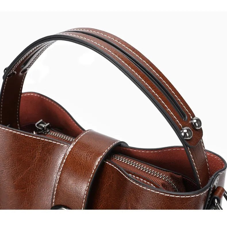 Gros plan sur la poignée du sac à main en cuir marron avec couture soignée.