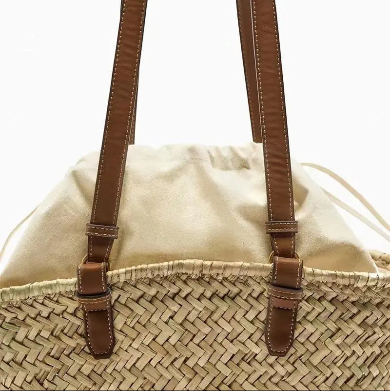 Zoom sur les anses en cuir brun du sac à main en paille tressée