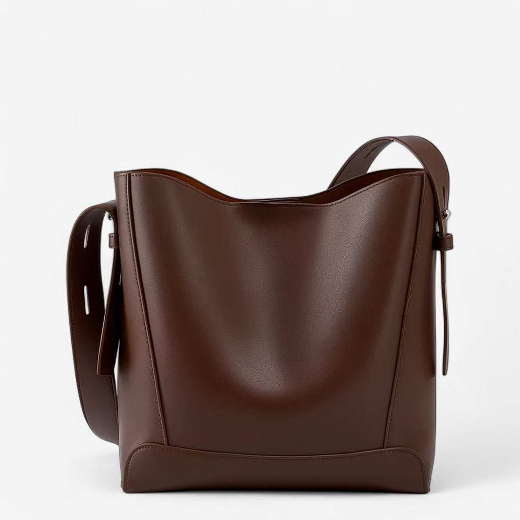 Vue de face d’un sac messager marron en cuir à bandoulière unique et structure souple.