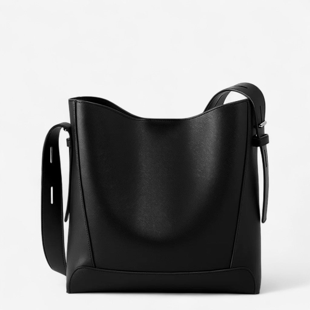 Vue de face d’un sac messager noir en cuir de vachette, forme seau structurée.