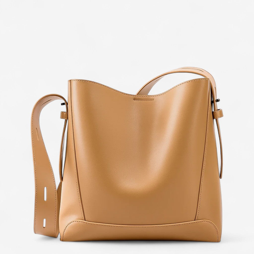 Sac messager femme en cuir de vachette camel, grande capacité avec bandoulière réglable et design seau structuré.