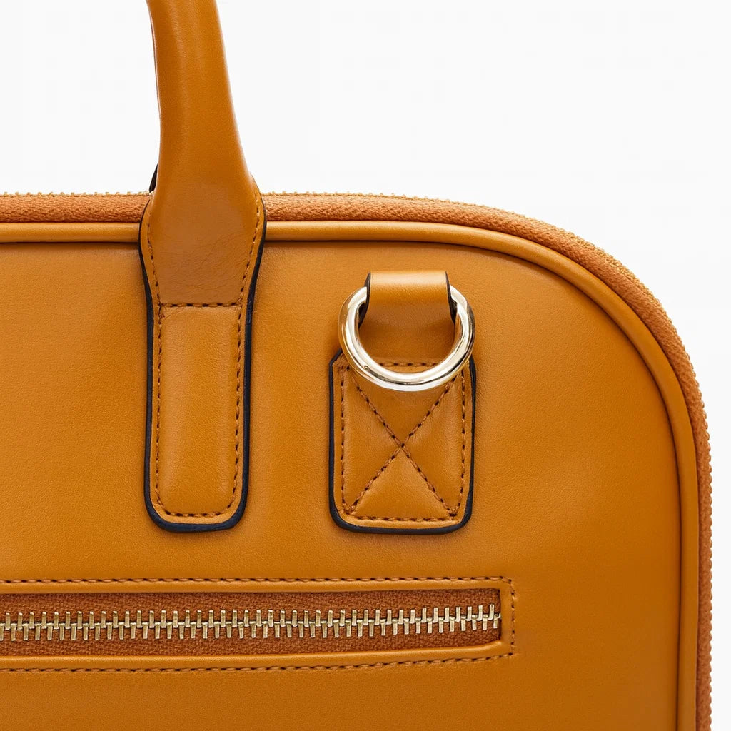 Détail de l’attache et de la poignée d’un sac ordinateur camel en cuir