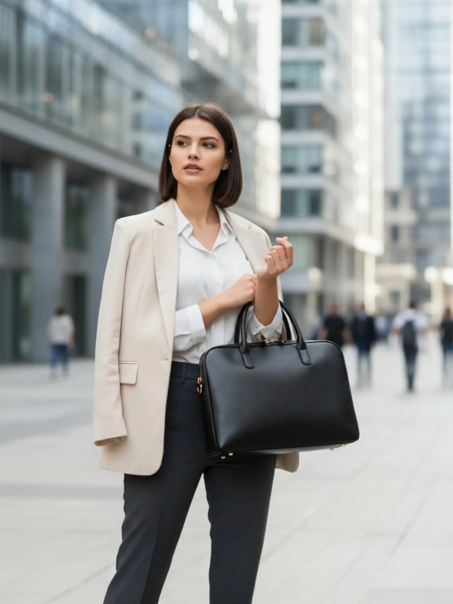 Femme d’affaires portant un sac ordinateur noir en cuir dans un environnement urbain