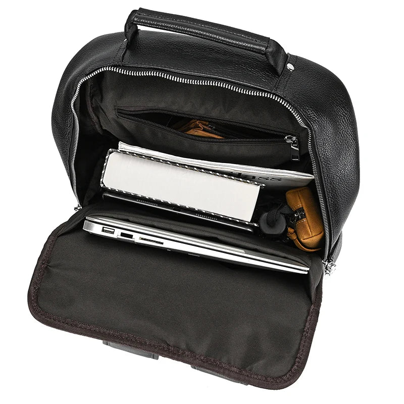 Intérieur du sac à dos en cuir noir avec ordinateur, carnet et accessoires