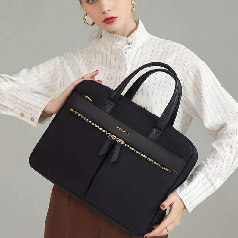 Femme en tenue professionnelle tenant un sac ordinateur noir devant elle