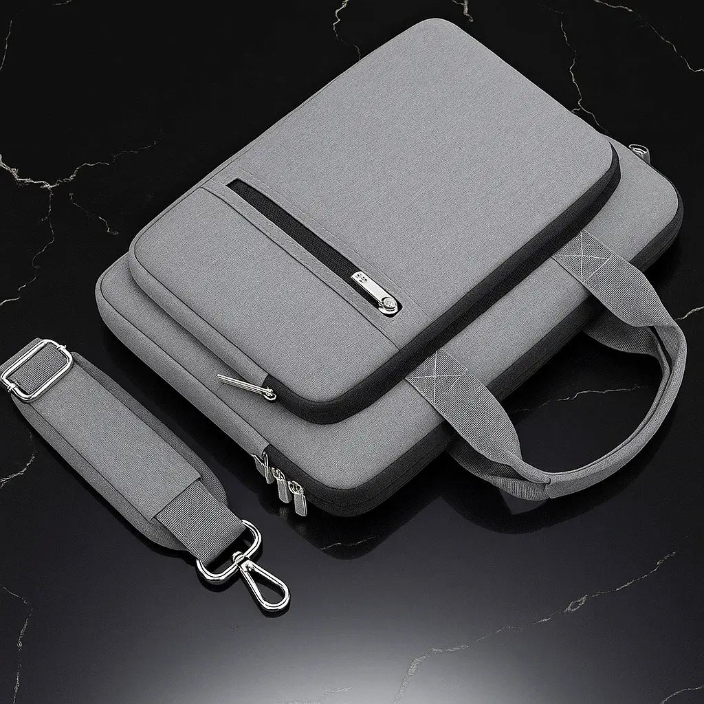 Sac pour ordinateur portable gris avec bandoulière détachable posée à côté