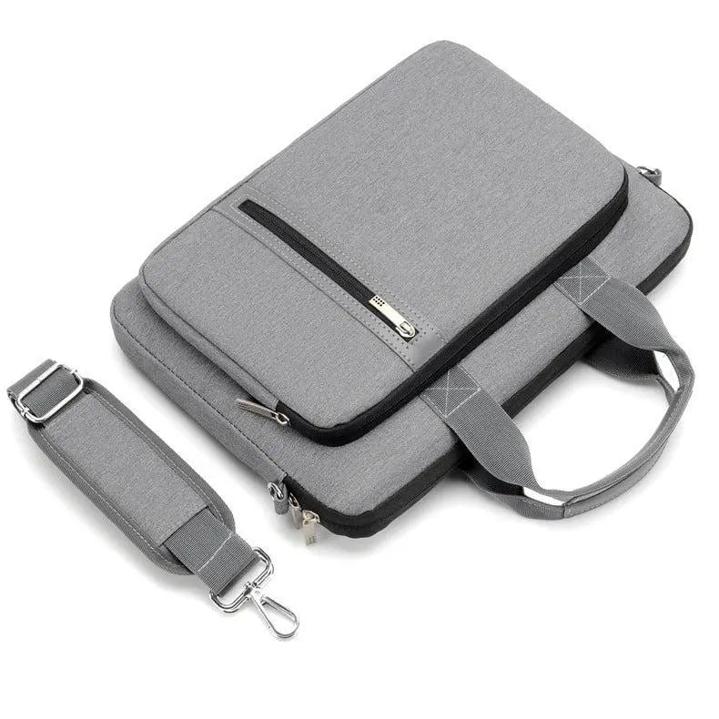 Sac pour ordinateur portable gris avec bandoulière détachable posée à côté