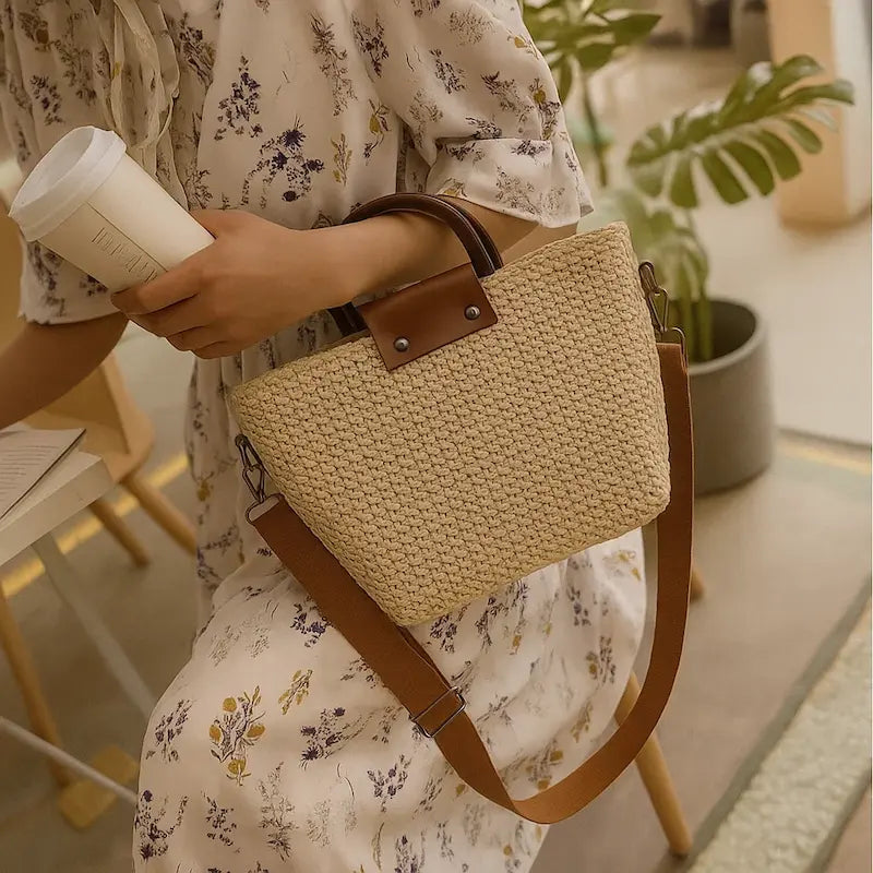 Sac en paille tressée beige avec anse rigide porté par une femme