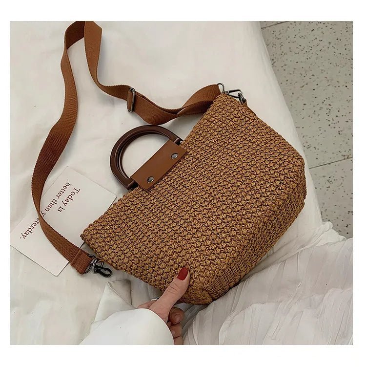 Sac en paille tressée marron clair avec anse rigide posé à plat