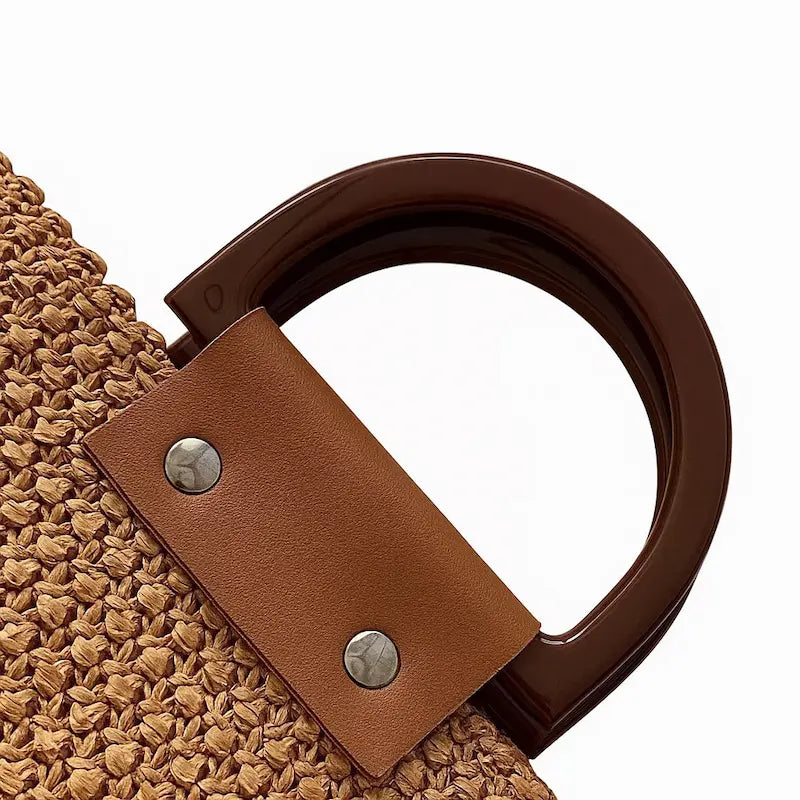 Zoom sur la anse rigide et la finition du sac en paille tressée