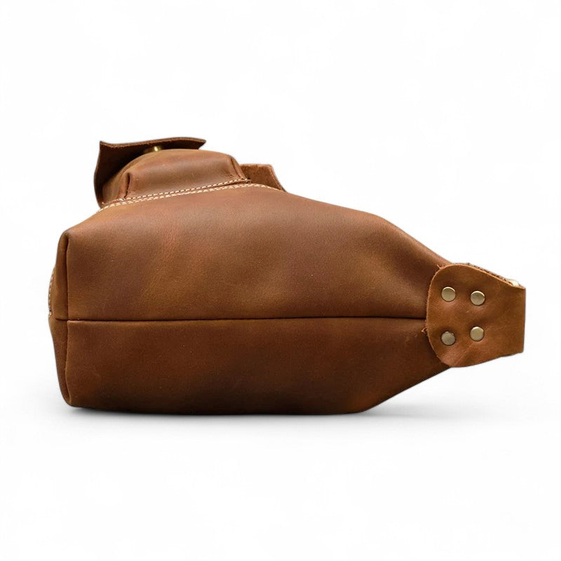 Vue de dessous du sac de poitrine en cuir vintage marron avec rivets métalliques