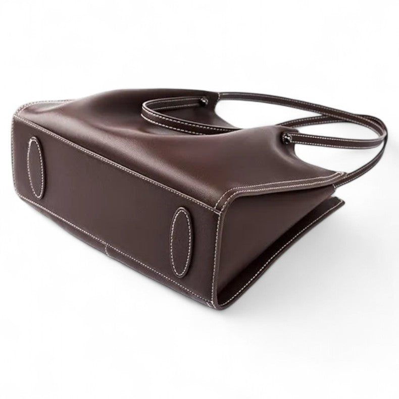 Vue du dessous du sac en cuir marron avec rivets métalliques de protection.