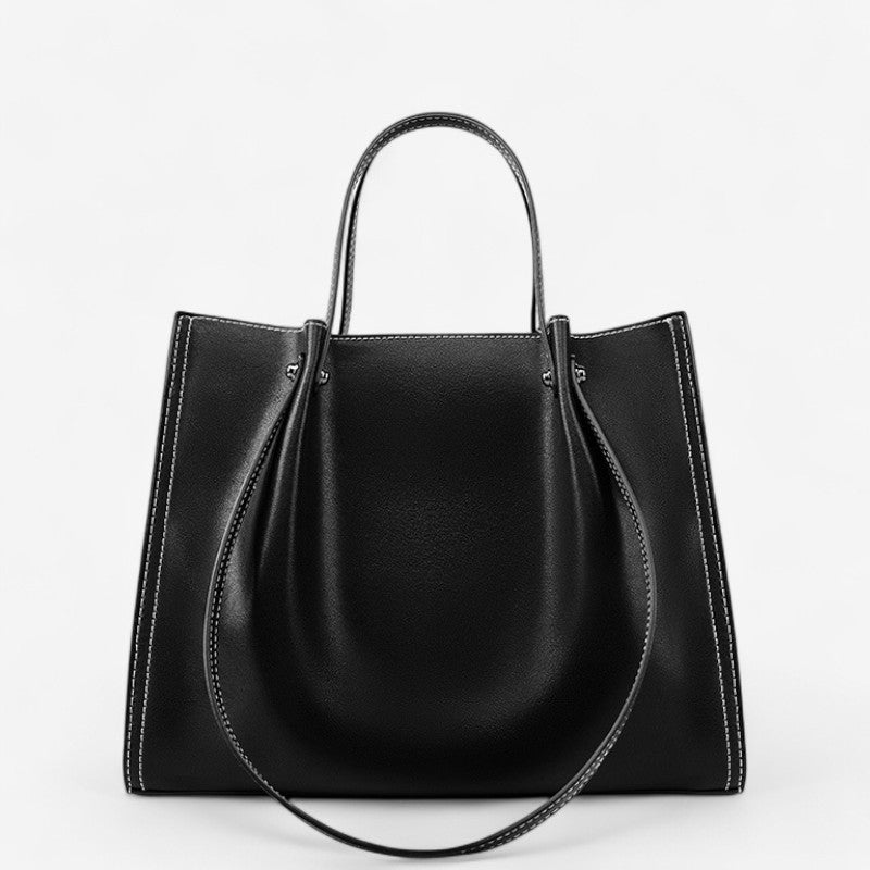 Vue de face du sac porté épaule en cuir noir au design structuré et élégant.