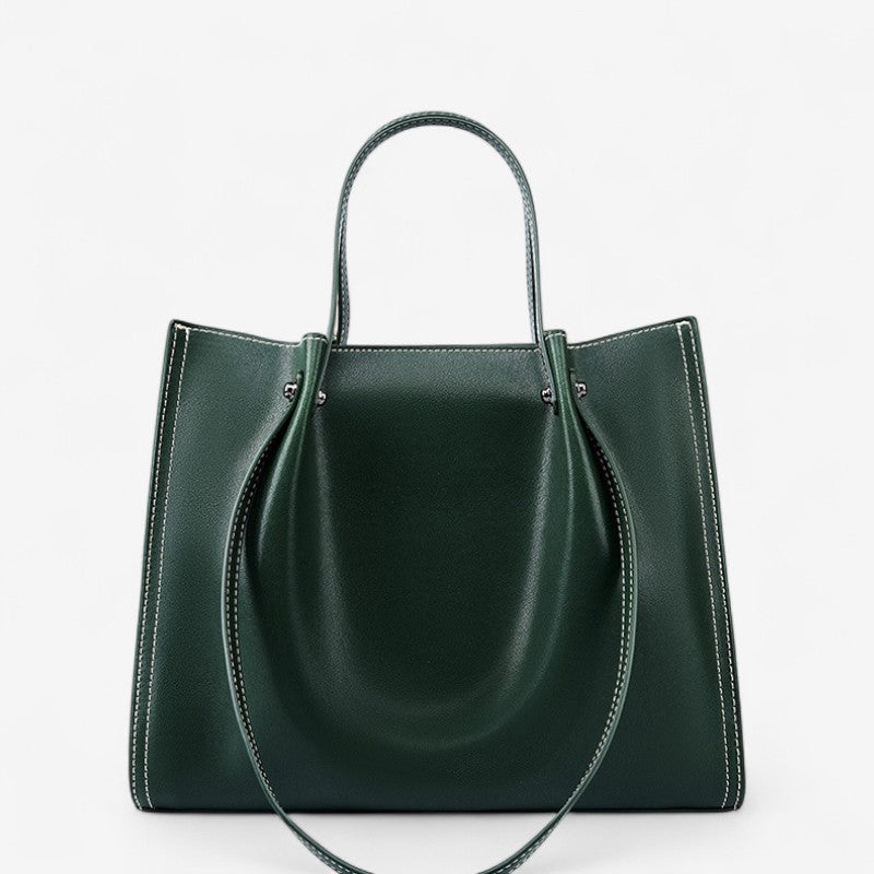 Vue de face du sac porté épaule en cuir vert foncé avec double anse et structure rigide.