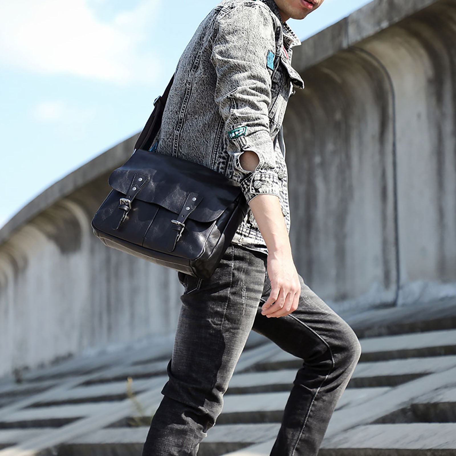 Homme portant un sac porte-documents en cuir noir en bandoulière