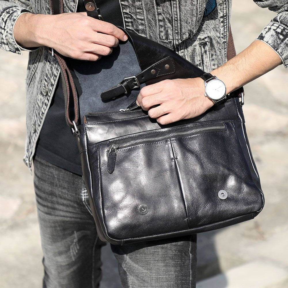 Homme tenant le sac porte-documents en cuir noir vintage à la main