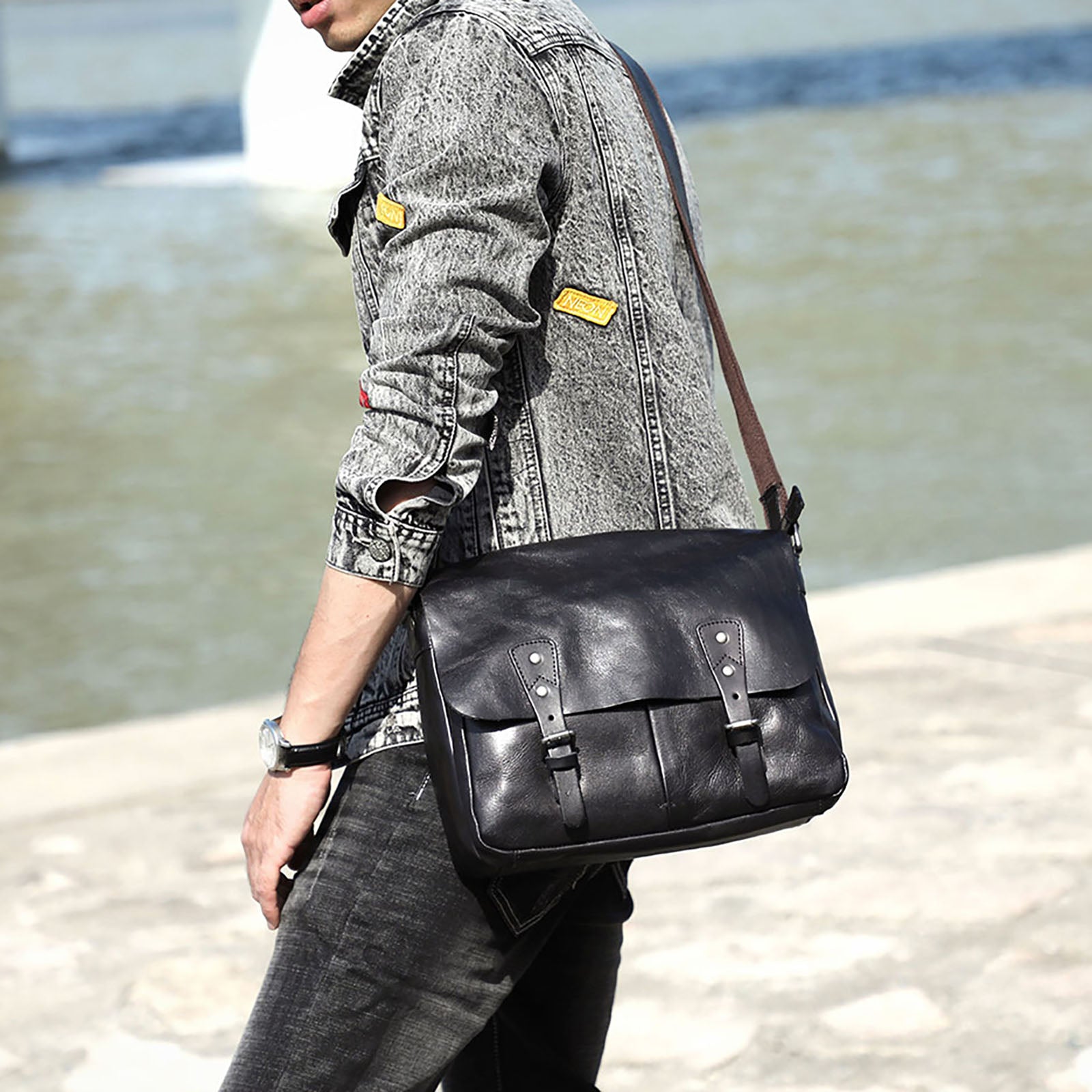 Homme portant le sac porte-documents en cuir noir au bord de l’eau