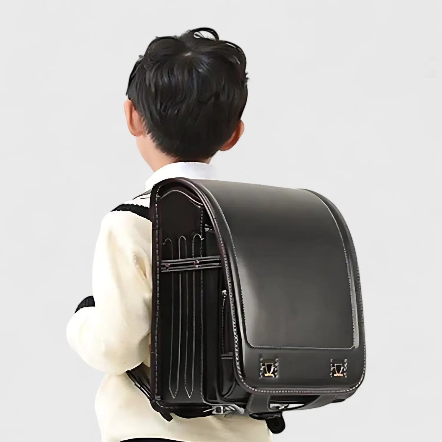 Jeune garçon portant un sac à dos japonnais randosoru de couleur noir sur les épaules 