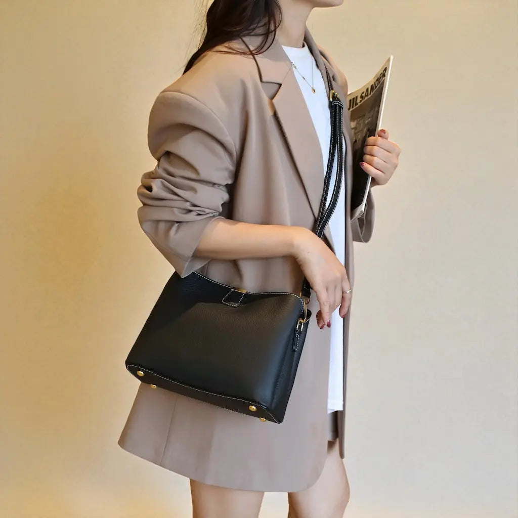 Sac seau femme en cuir véritable noir porté en bandoulière