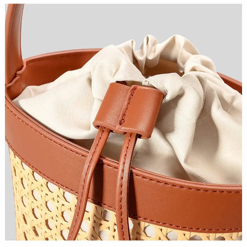 Détail du cordon de serrage en tissu beige sur sac seau en rotin bohème
