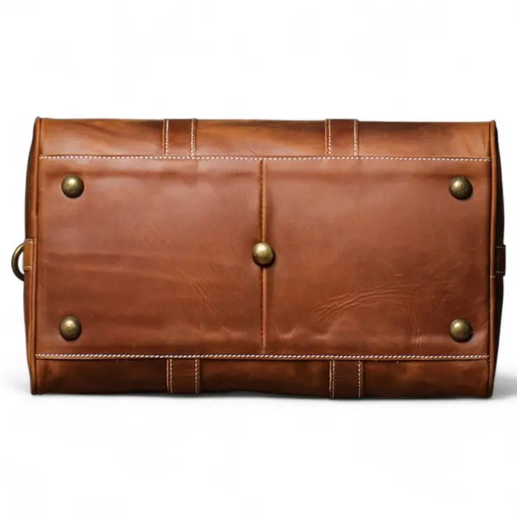 Dessous du sac de voyage en cuir marron avec pieds de protection métalliques