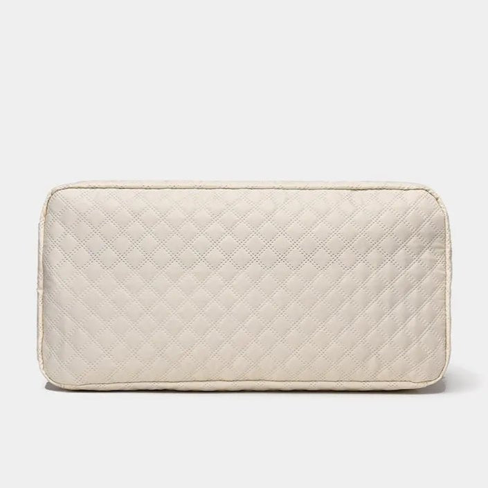 Vue de la base d’un sac de voyage femme beige matelassé