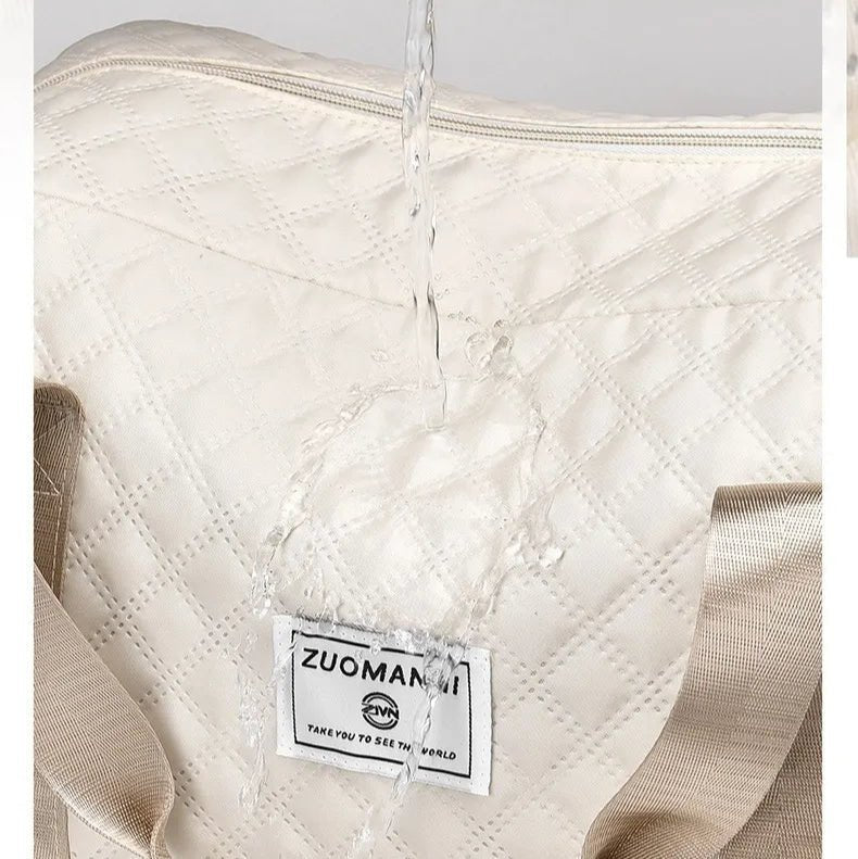 Détail du logo intérieur sur tissu matelassé d’un sac de voyage femme beige