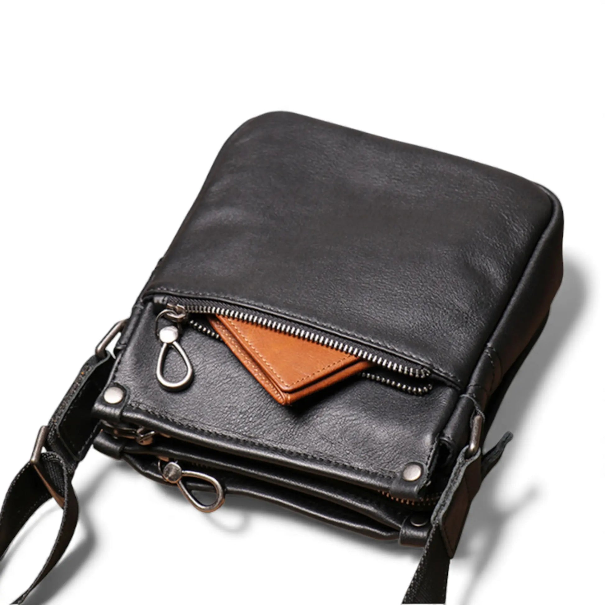 Sacoche en cuir noire avec poche avant ouverte et portefeuille visible