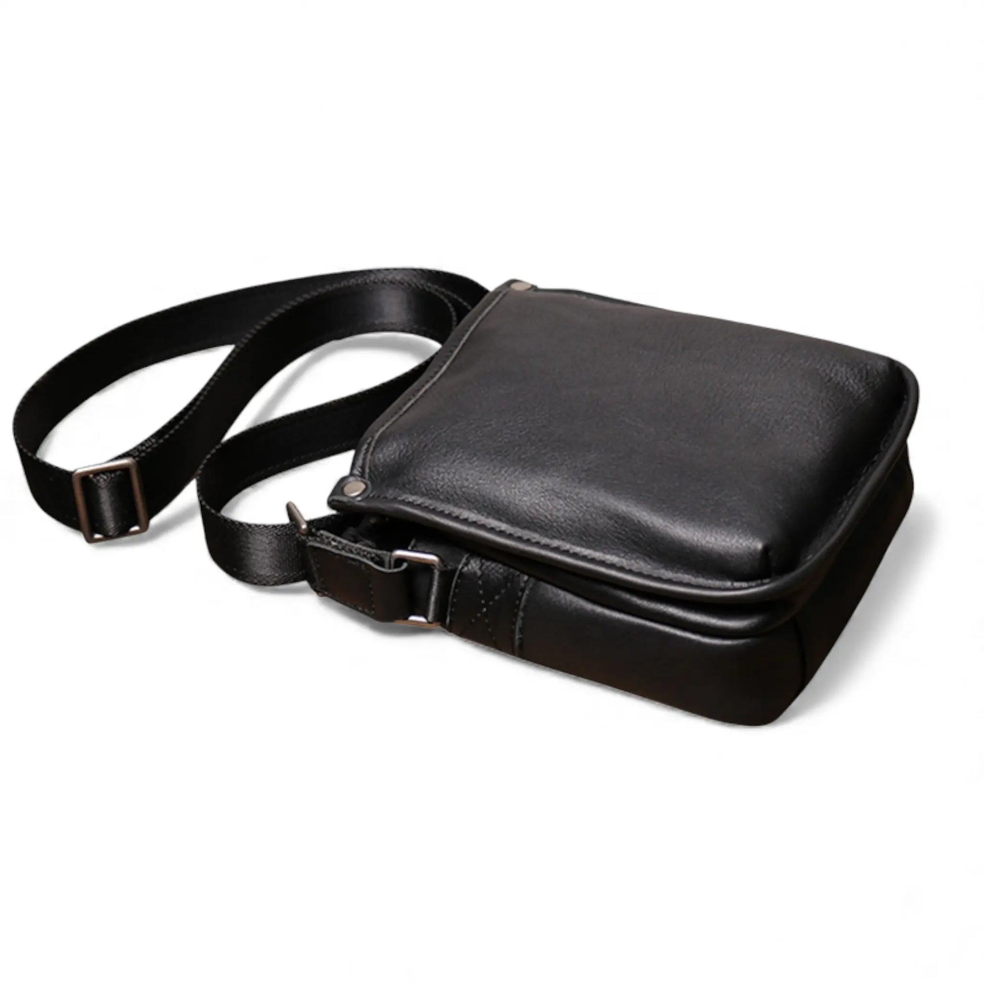 Sacoche en cuir noire posée à plat avec la bandoulière visible