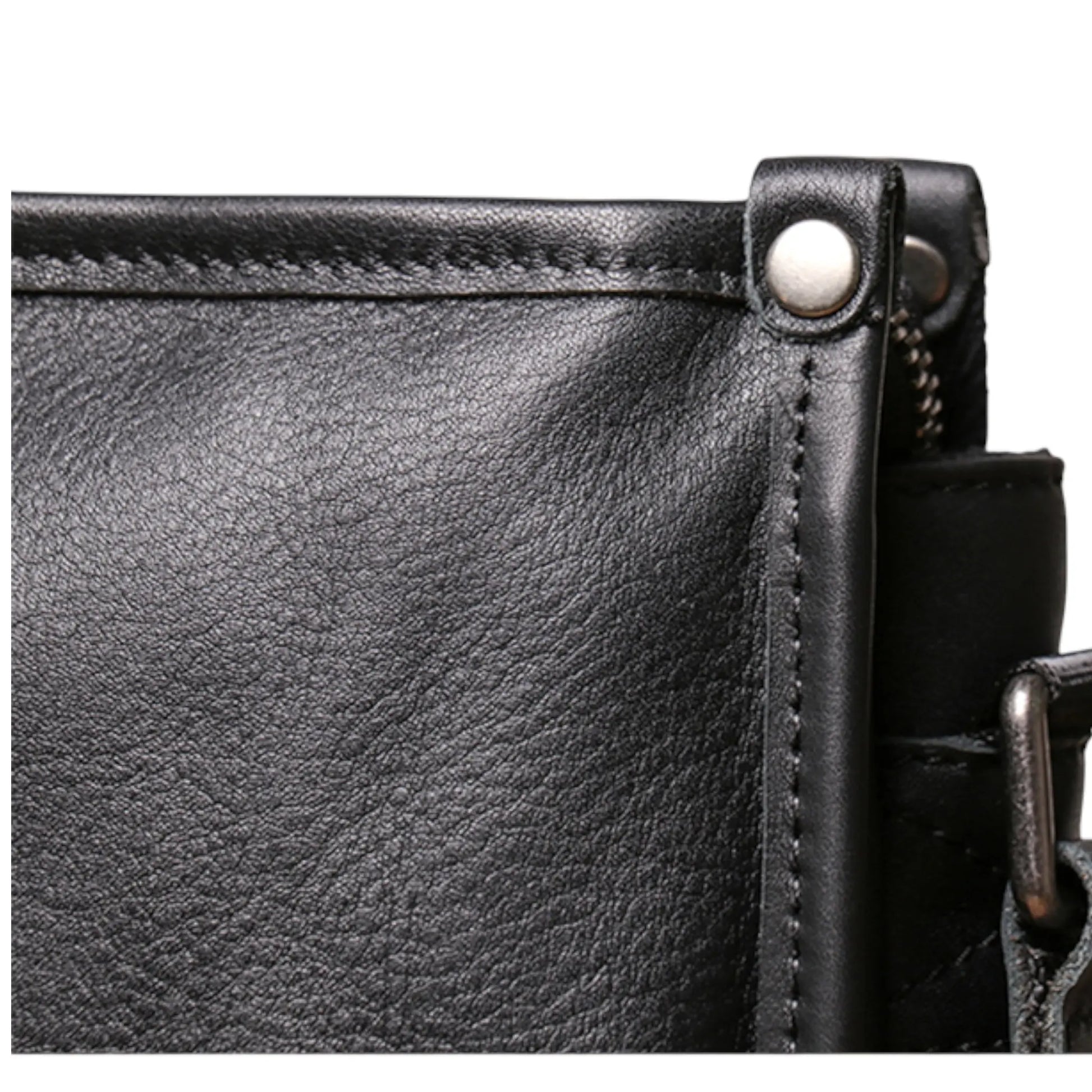 Zoom sur la couture et le rivet latéral d’une sacoche en cuir noire